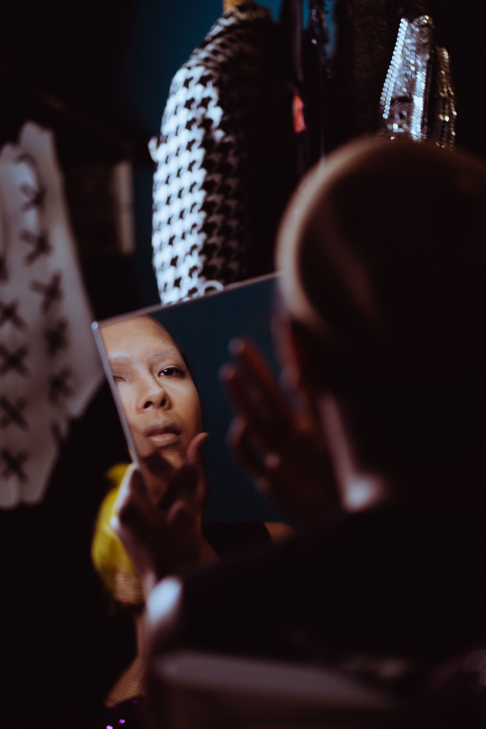 Woman checking her foundation in a handheld mirror