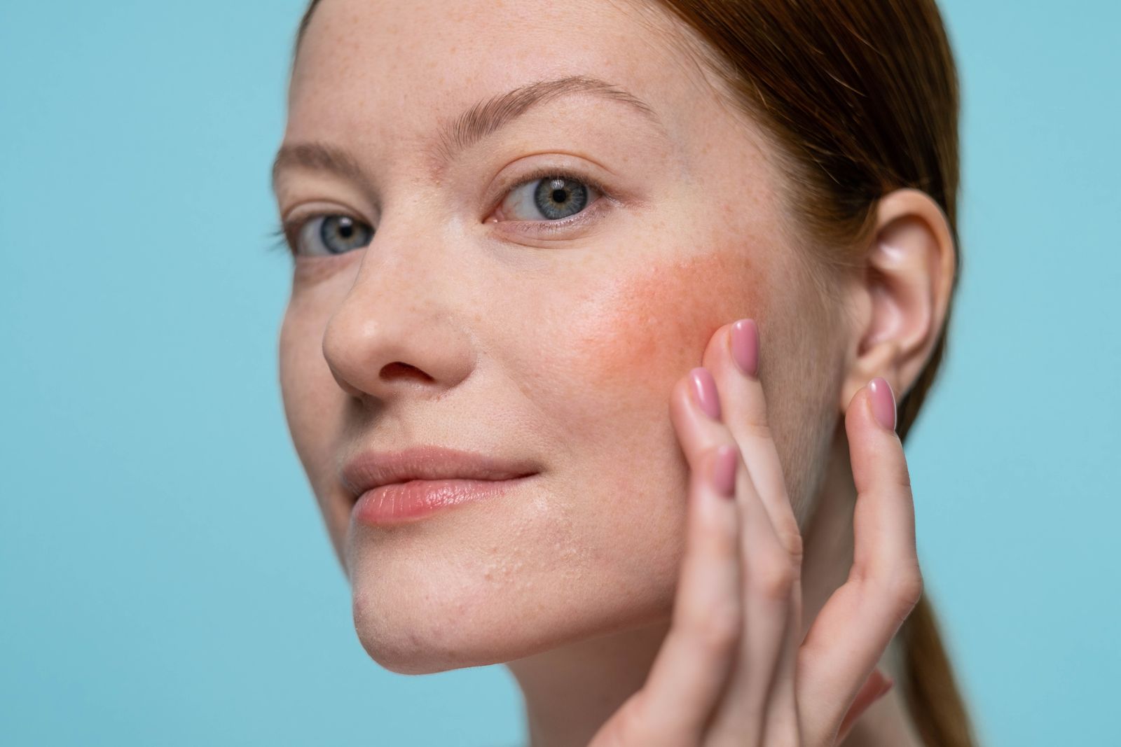 Woman applying a small amount of blush to her cheek