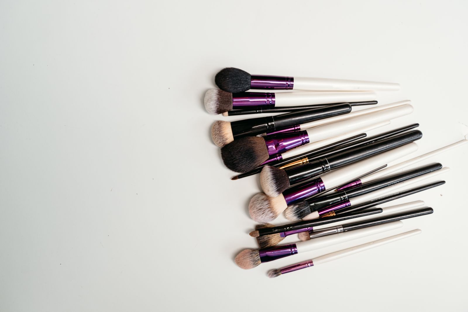 Makeup brushes arranged on a white surface