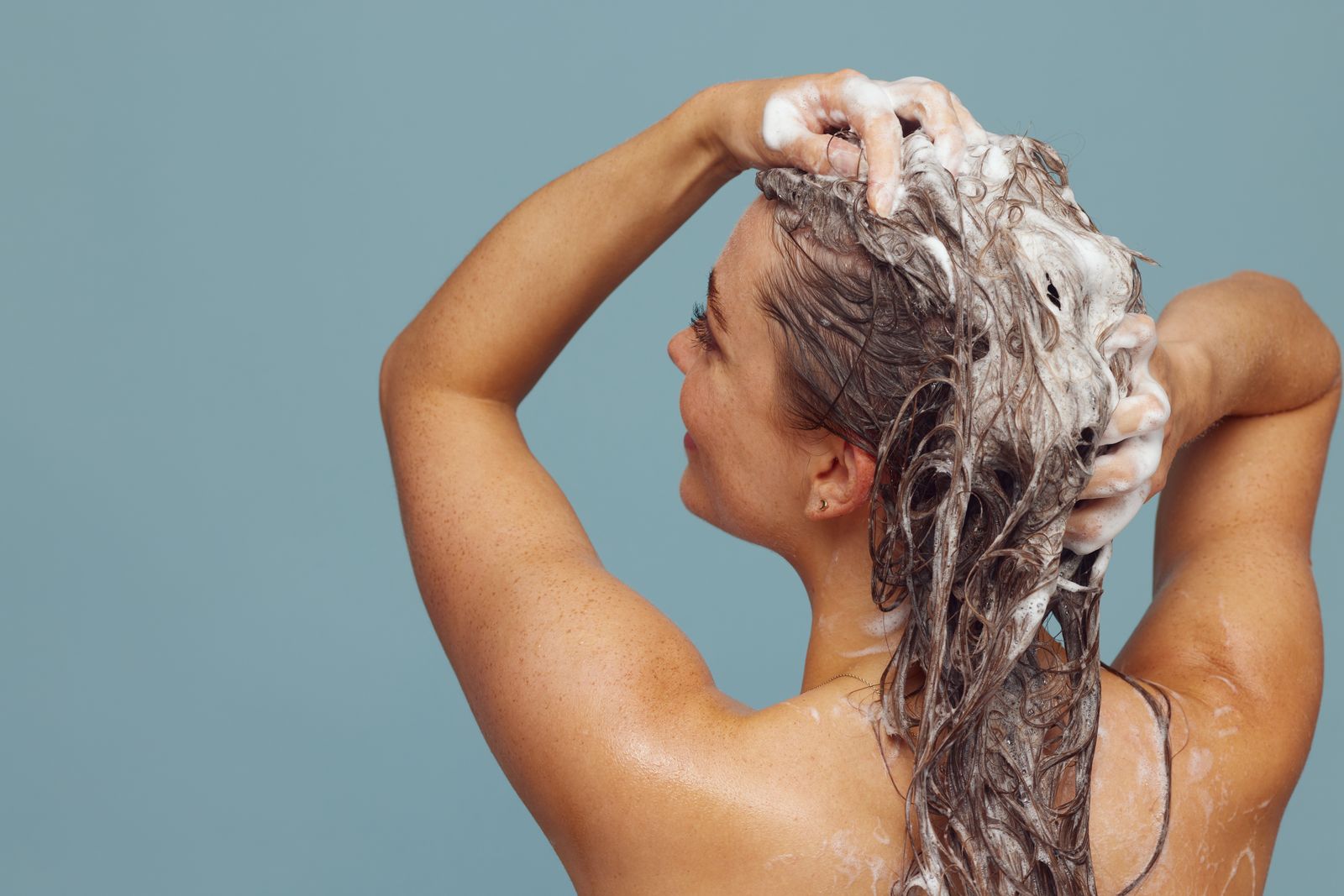 Woman massaging shampoo into her hair and scalp