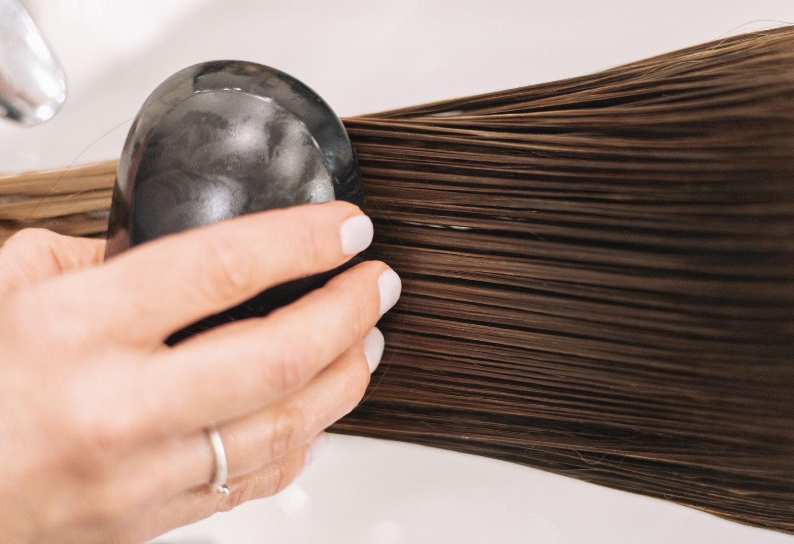 Woman gently brushing long brown hair